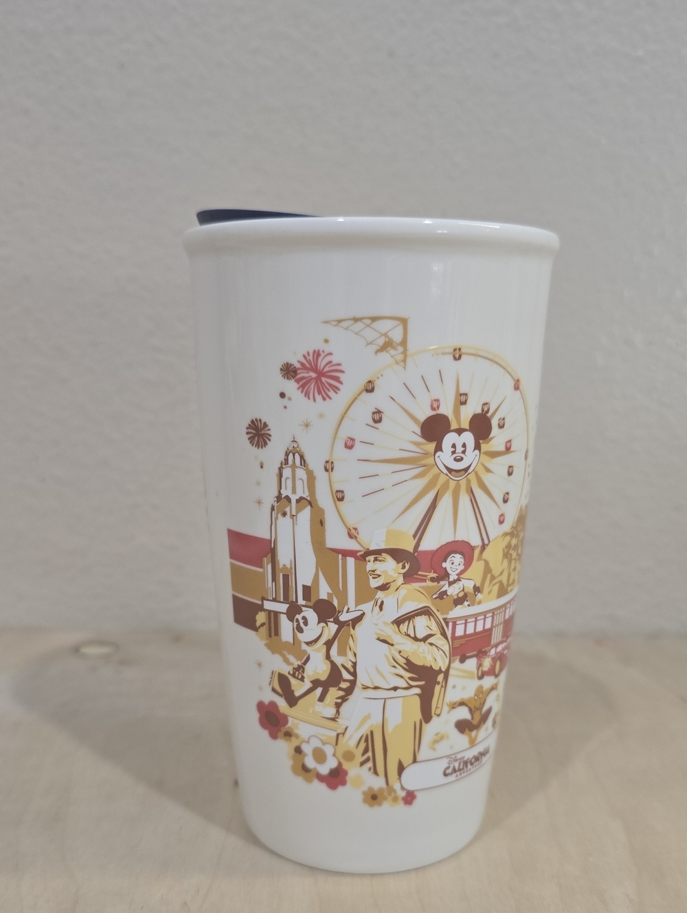 Disney White Ceramic Travel Cup with Gold and Red Park Scene